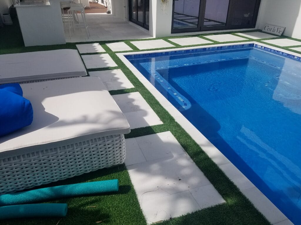 a pool with a white wicker basket and a mat smart synthetic turf