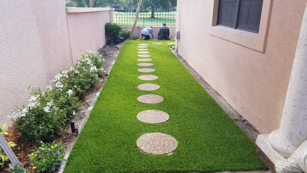 a man working on a path in a yard smart synthetic turf