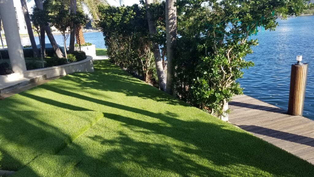 a lawn with trees and a dock by the water smart synthetic turf