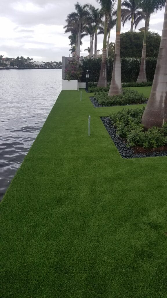 a grass lawn next to a body of water smart synthetic turf